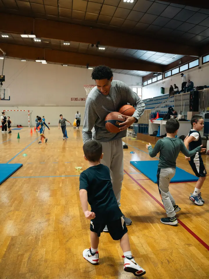 Un coach montre un geste à de jeunes joueurs au gymnase