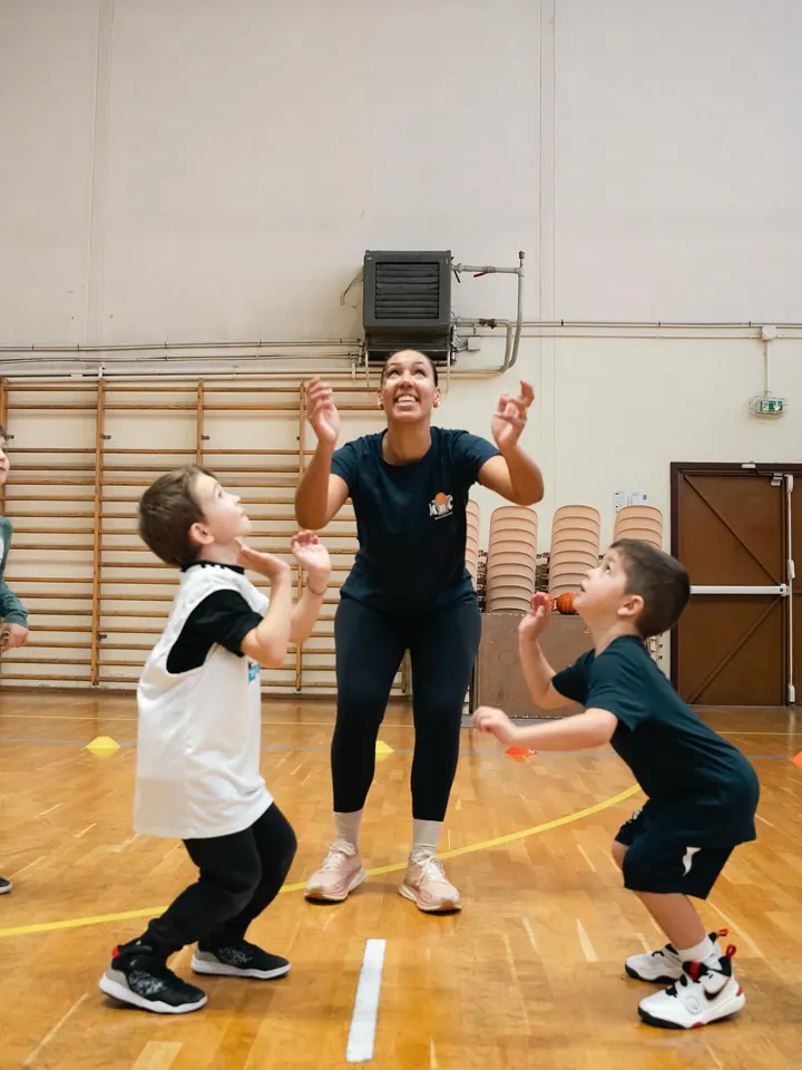 Une coach montre un geste à deux jeunes joueurs